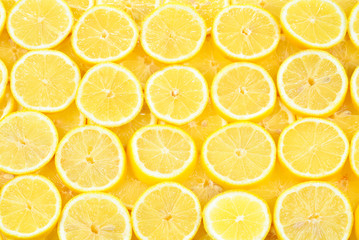 A slices of fresh juicy yellow lemons.  Texture background, pattern.