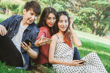 Asian student selfies in park with friend