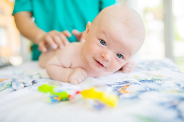 Doctor masseur wearing uniform massaging little baby