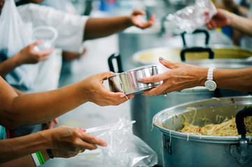 The hands of beggars offer food from the donor : The life of the poor