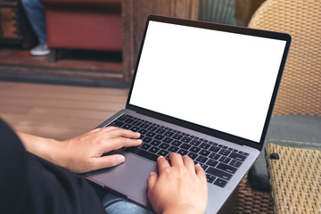 Mockup image of hands using and typing on laptop with blank white desktop screen while sitting outdoor