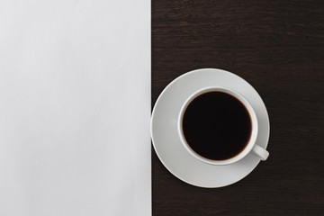 Still life, black coffee in a white cup on a brown-white wooden background