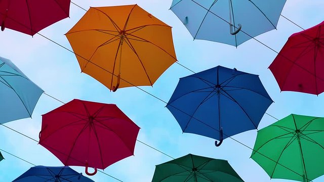 Flying Umbrellas. Multi colored Parasol Soar in the Sky. Umbrellas Suspended Above their Heads. Street Decorations of the City