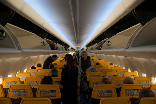 People arranging their luggage before the flight in the economy class