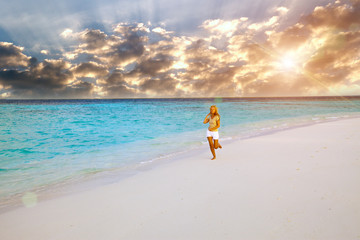Fototapeta na wymiar The woman runs on sea coast, Maldives