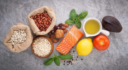 selection of healthy food. Salmon fish, nuts, salt, pepper, fruits and vegetables on stone background from top view.