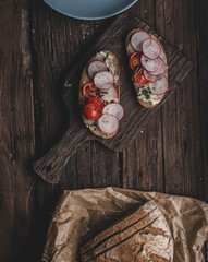 Homemade bread with fresh creame, herbs and radishes