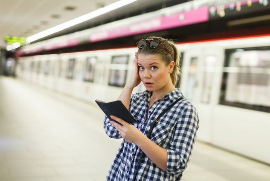 Woman with phone at underground station