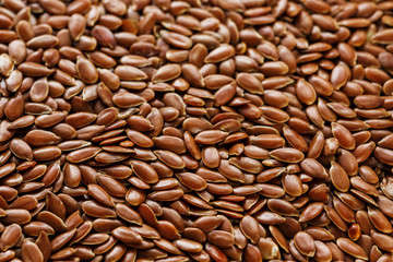 Background texture of seeds of dark brown flax.