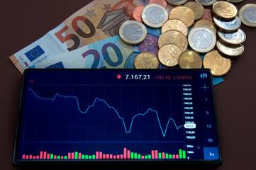 trading schedule on smartphone banknotes and coins