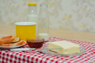 Mug of milk, bottles of milk, butter, jam, toast - a tasty and fast nutritious breakfast.