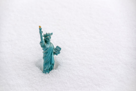 Statue Of Liberty Miniature In The Snow. Winter Snowfall In New York Concept