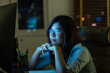 Portrait of Asian Businesswoman working hard and looking the digital graphic on the table with...