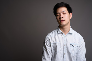 Portrait of young Asian businessman with eyes closed