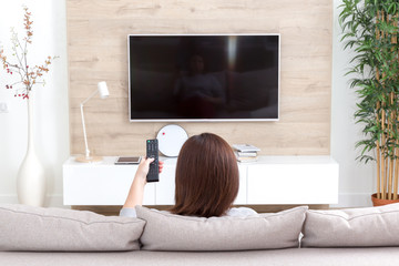 Fototapeta Young woman watching TV in the room obraz