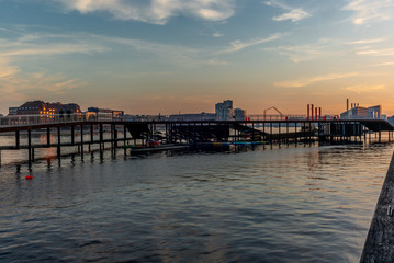 Waterside pedestrian bridge in Copenhagen at sunset with a people running in the background with motion blur effect