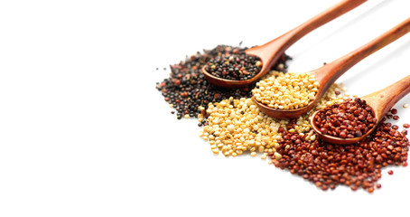 Quinoa. Red, black and white quinoa grains in a wooden spoons isolated on white background. Healthy food. Chenopodium quinoa