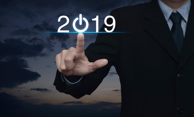Businessman pressing 2019 start up business icon over sunset sky, Happy new year 2019 concept