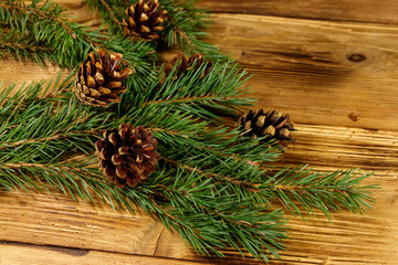 Christmas composition with fir tree branches and cones on wooden background