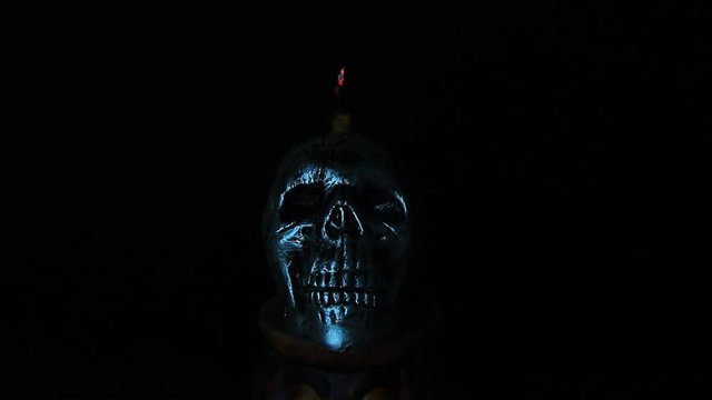 Halloween dark scary horror story ideas concept with jocker candle light and silver skull human isolated on black background