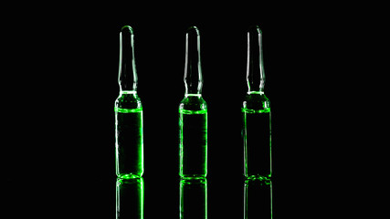 green ampoules on a black background. Narcotic acid. low key photo.