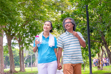 The old couple relax after jogging. They hold their hands and smile. They love and they are sweet.Sweetheart, Life style, Exercise ,Photo concept love and healthy.