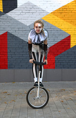 Girl clown performing with a unicycle