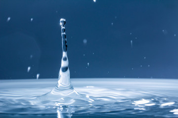 Drops of rain fall into the water, selective focus close-up