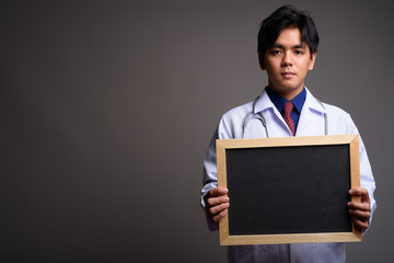 Asian man doctor holding empty blackboard with copyspace