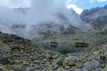 peak of Rysy mountain covered in mist. autumn ascent on hiking trails