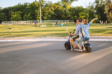 Lovely young couple driving electric bike. Modern city transportation