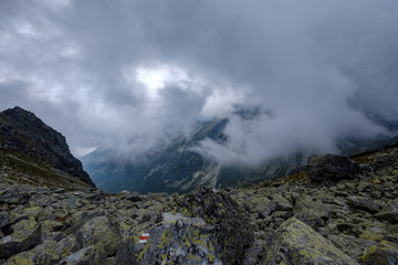 peak of Rysy mountain covered in mist. autumn ascent on hiking trails