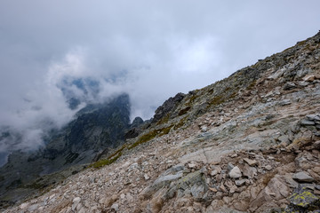 Fototapeta na wymiar peak of Rysy mountain covered in mist. autumn ascent on hiking trails