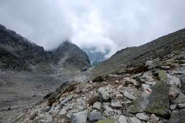 peak of Rysy mountain covered in mist. autumn ascent on hiking trails