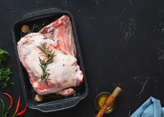 Shoulder of lamb ready  before slow cooking. Top view, blank space, rustic, dark background