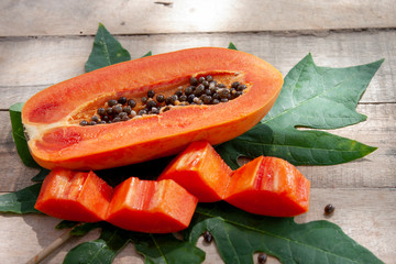 Slices piece of sweet papaya fruit on wooden table.
