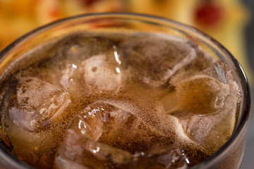 fizzy drink with ice in a glass on the abstract background