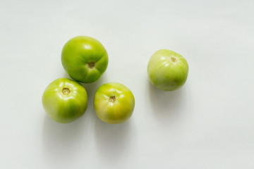 green tomatoes on white background, top view