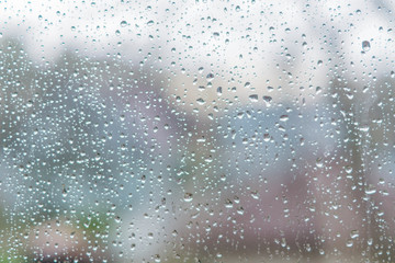 Naklejka na ściany i meble Rain drops on a window glass. Abstract background texture. Defocised image
