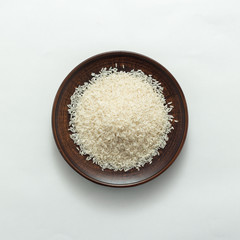 White rice in bowl on white background top view