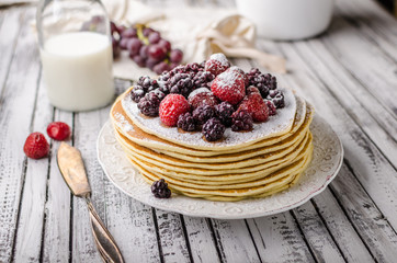 Homemade crepes with frozen berries, topped sugar