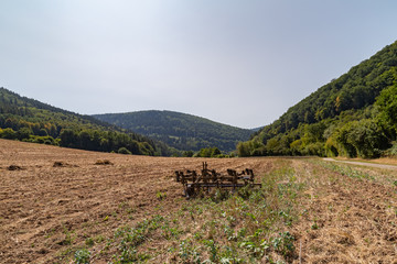 harrow on a field surrounded by forest