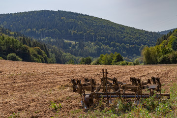 harrow on a field surrounded by forest