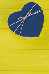 Valentine Heart Blue Gift Box. Yellow Wood Background.