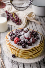 Homemade crepes with frozen berries, topped sugar