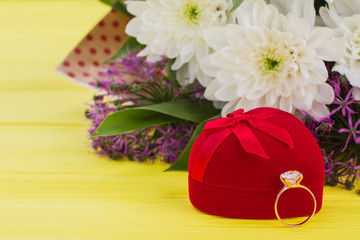 Diamond ring, gift box and flowers. Valentines holiday background with ring and bouquet of flowers. Marriage proposal concept.