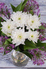 Luxury bouquet of fresh flowers. White chrysnathemums and purple allium background. Holiday greeting card.