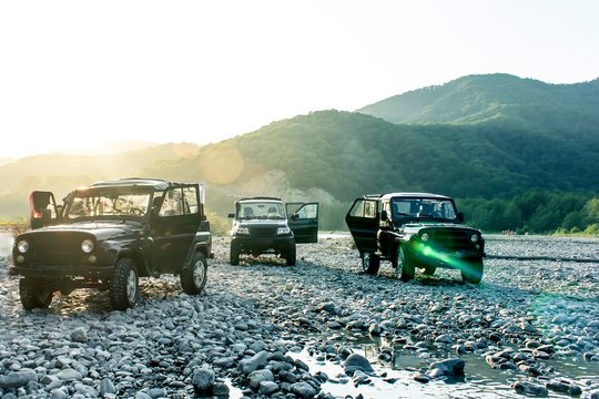 Travel concept with big 4x4 car against sunset and mountains. Closeup photo of offroad wheel
