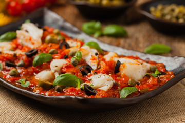 Cod in Italian in tomatoes with olives and capers.