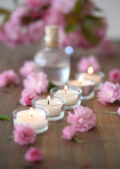 Closeup of burning candles and blossoms with bokeh 
